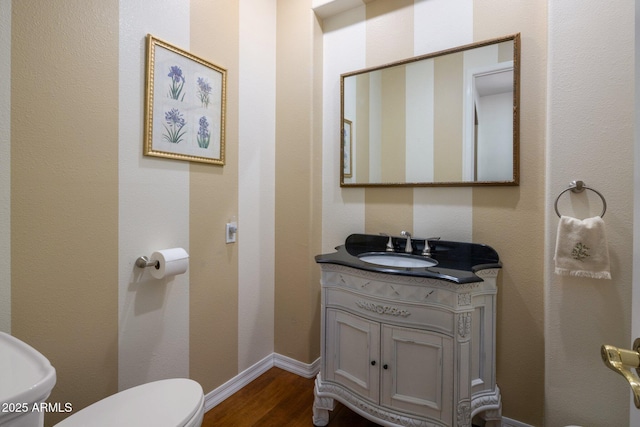 bathroom with wood-type flooring, vanity, and toilet