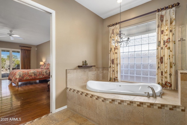 bathroom with ceiling fan, wood-type flooring, and tiled bath