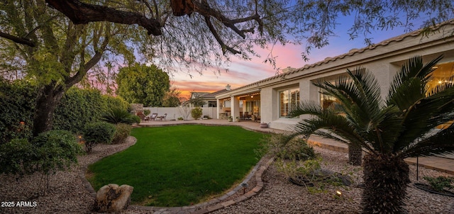 yard at dusk featuring a patio area