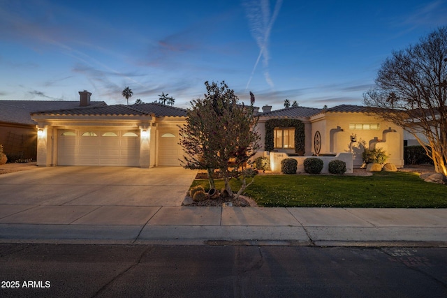 mediterranean / spanish-style home with a yard and a garage