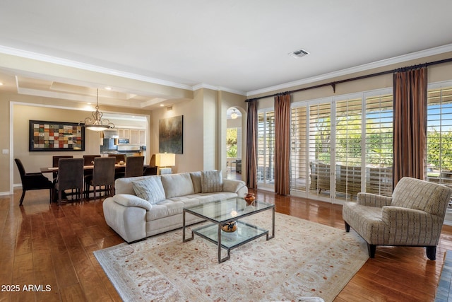 living room featuring hardwood / wood-style flooring, ornamental molding, and a wealth of natural light