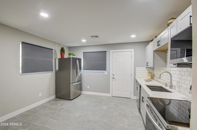 kitchen with sink, white cabinetry, decorative backsplash, and stainless steel appliances