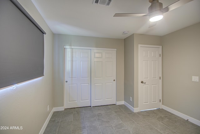 unfurnished bedroom featuring ceiling fan and a closet