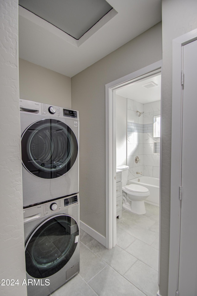 laundry area featuring light tile patterned floors and stacked washer and dryer