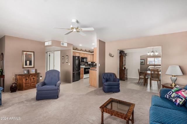 living room with ceiling fan with notable chandelier and light colored carpet