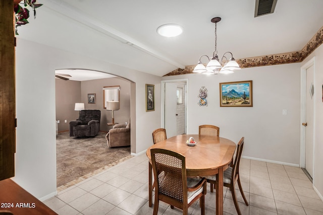 tiled dining space with vaulted ceiling with beams and a chandelier