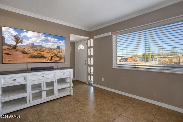 tiled entrance foyer featuring a textured ceiling and crown molding