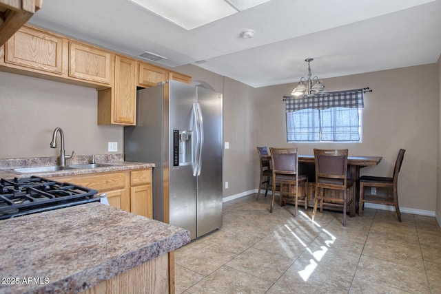 kitchen with sink, stainless steel appliances, a chandelier, decorative light fixtures, and light brown cabinetry