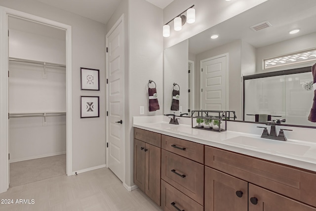 bathroom with double vanity, a sink, visible vents, and a shower stall