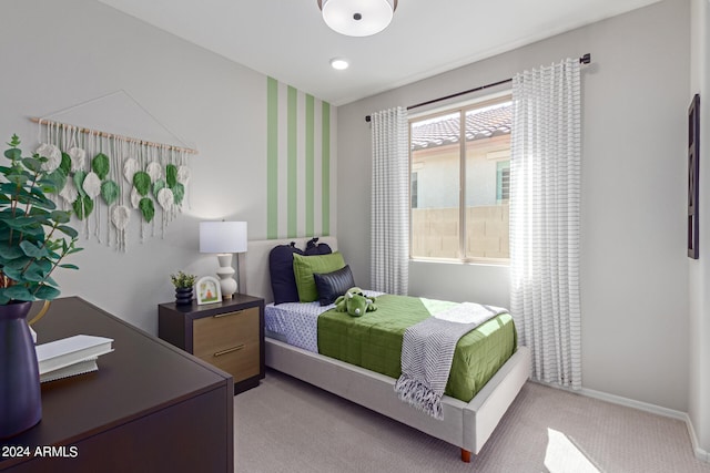 bedroom with light colored carpet and baseboards