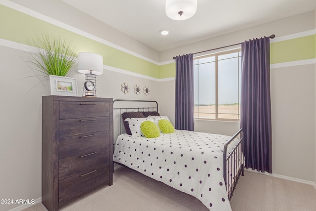 bedroom featuring light carpet and baseboards