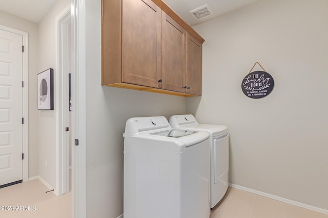 washroom featuring baseboards, visible vents, cabinet space, and washing machine and clothes dryer