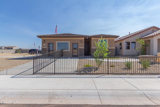 view of front facade with fence and stucco siding