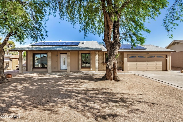 308 W Oraibi Dr, Phoenix, AZ 85027 - view of front facade featuring roof mounted solar panels, concrete driveway, and an attached garage