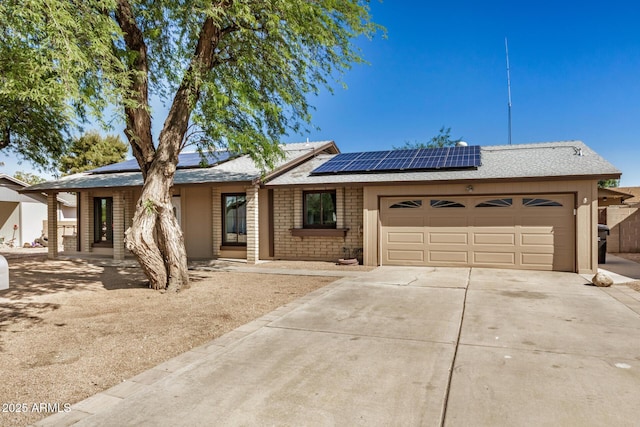 308 W Oraibi Dr, Phoenix, AZ 85027 - view of front facade featuring a garage, driveway, and roof mounted solar panels