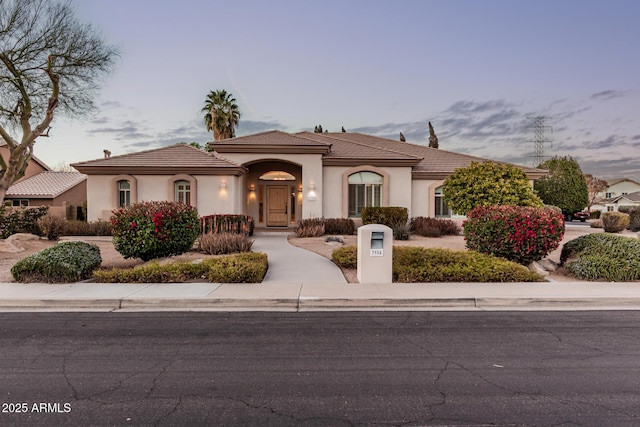 mediterranean / spanish-style home featuring a tile roof and stucco siding