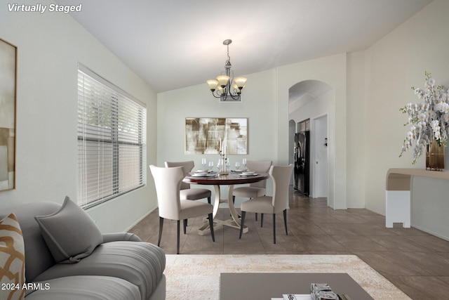 dining area featuring tile patterned flooring, vaulted ceiling, and a notable chandelier