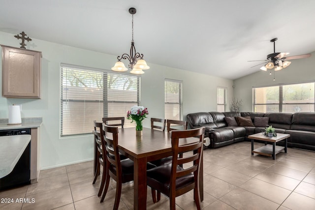 dining space featuring ceiling fan with notable chandelier, light tile patterned flooring, and lofted ceiling