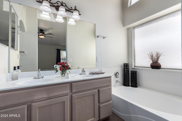 bathroom with a washtub, ceiling fan, and vanity