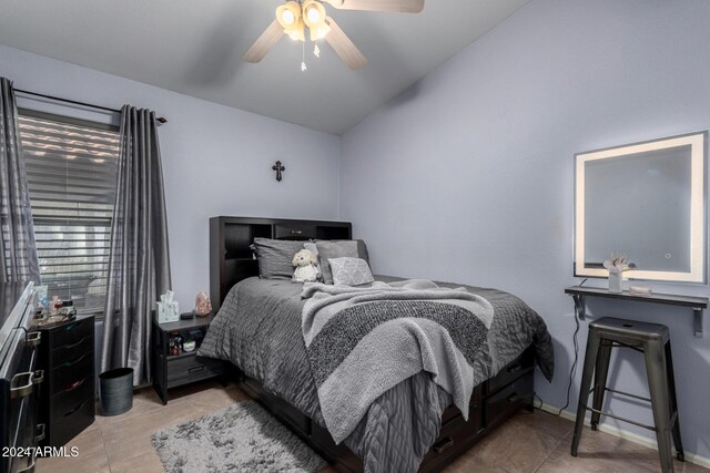 bedroom featuring ceiling fan, light tile patterned floors, and vaulted ceiling