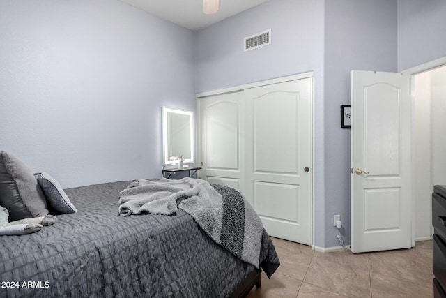 bedroom featuring ceiling fan, a closet, and light tile patterned floors