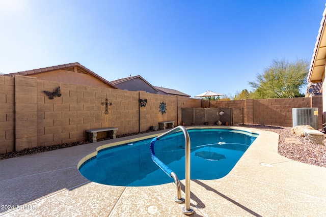 view of pool featuring a patio and central AC unit