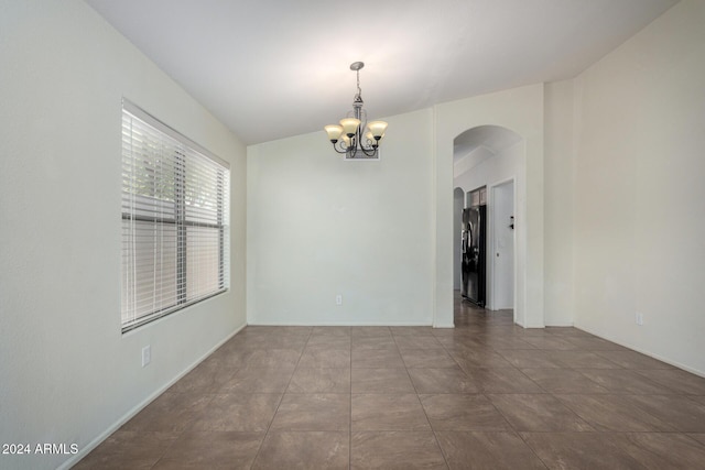 empty room featuring tile patterned floors and a notable chandelier