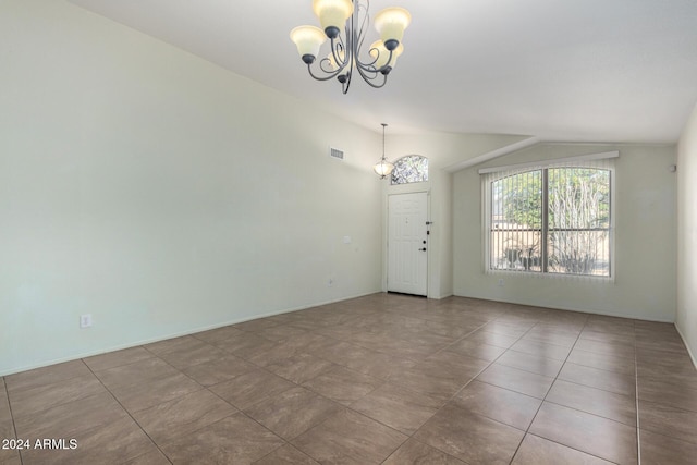 tiled spare room featuring lofted ceiling and an inviting chandelier