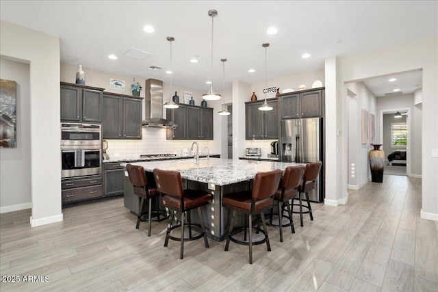 29344 N 132nd Ln, Peoria, AZ 85383 - kitchen featuring wall chimney exhaust hood, appliances with stainless steel finishes, tasteful backsplash, a breakfast bar, and recessed lighting