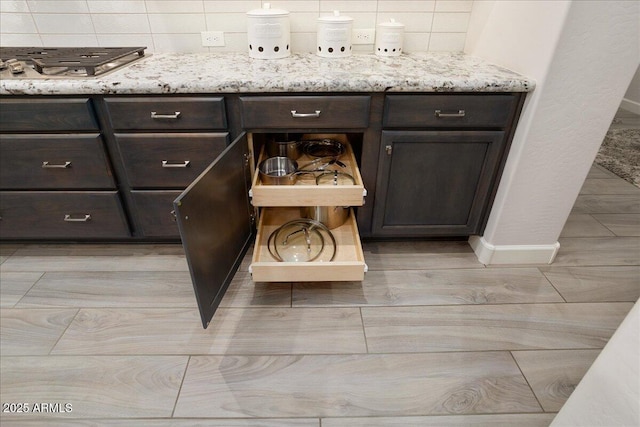 29344 N 132nd Ln, Peoria, AZ 85383 - detailed view of stainless steel gas cooktop, dark brown cabinets, open shelves, light stone counters, and baseboards