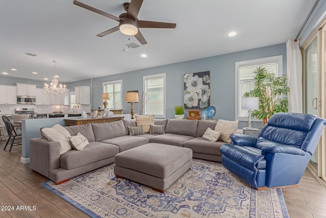 living room featuring light hardwood / wood-style floors and ceiling fan with notable chandelier