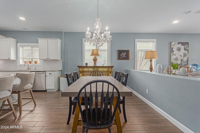 dining space with an inviting chandelier, sink, and dark hardwood / wood-style flooring