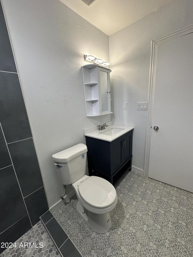 bathroom featuring tile patterned floors, toilet, and vanity