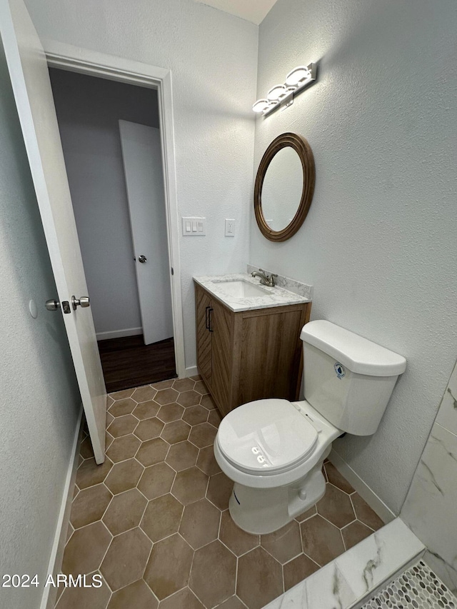 bathroom with toilet, hardwood / wood-style floors, and vanity