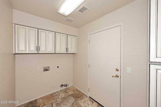 washroom featuring hookup for a gas dryer, hookup for an electric dryer, washer hookup, light stone finish floors, and cabinet space