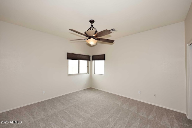 carpeted empty room with ceiling fan and baseboards