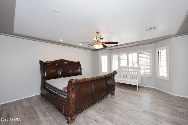 bedroom with wood finished floors, multiple windows, baseboards, and recessed lighting