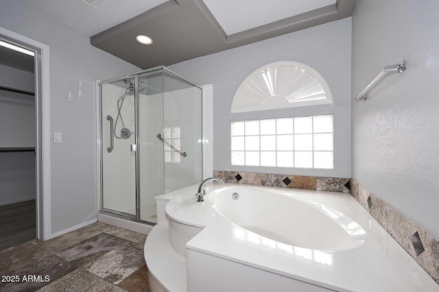 full bathroom with a stall shower, a bath, and a walk in closet