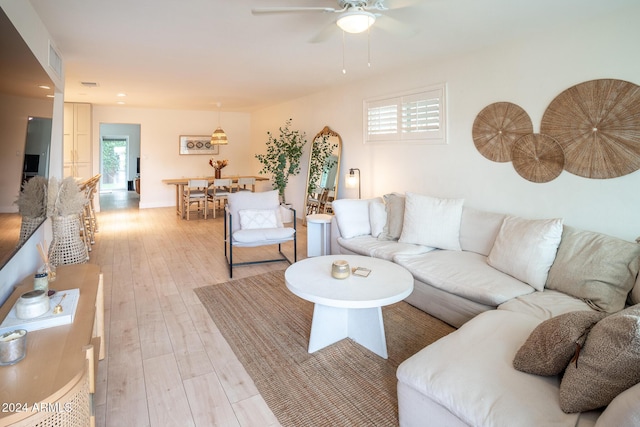 living room with light wood-type flooring and ceiling fan