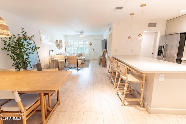 dining room with ceiling fan and light hardwood / wood-style flooring