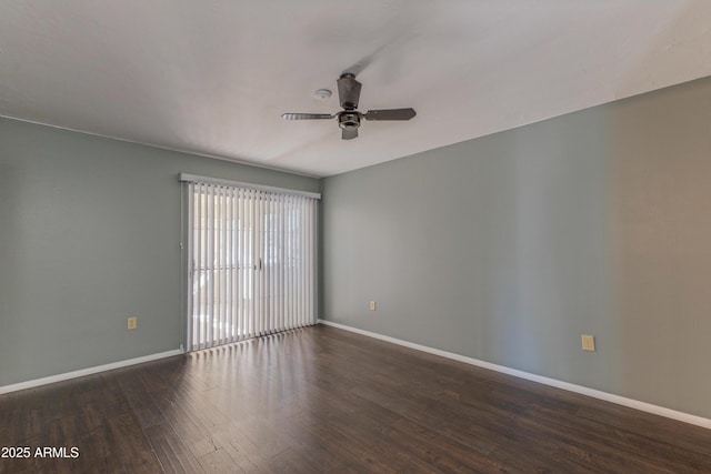 spare room featuring dark wood-style floors, ceiling fan, and baseboards