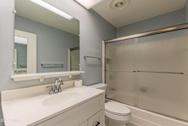 bathroom with enclosed tub / shower combo, vanity, and toilet
