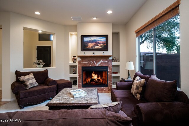 living room featuring a premium fireplace, baseboards, visible vents, and recessed lighting