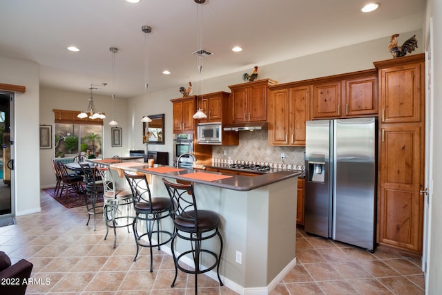 kitchen featuring visible vents, appliances with stainless steel finishes, brown cabinets, under cabinet range hood, and recessed lighting