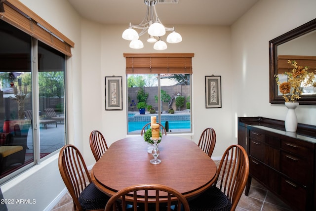 dining space featuring baseboards, a notable chandelier, and tile patterned floors