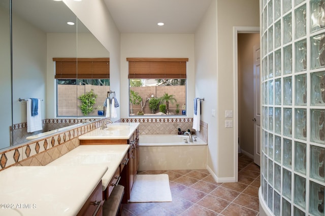 full bathroom with tile patterned flooring, vanity, recessed lighting, baseboards, and a garden tub