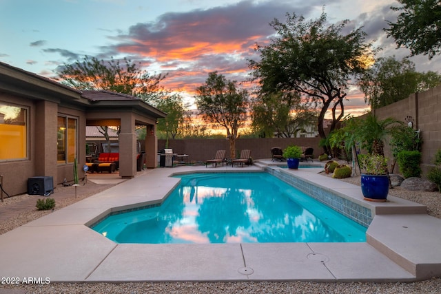 view of swimming pool with area for grilling, a patio, a fenced in pool, and a fenced backyard