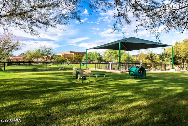 view of property's community with a lawn and fence