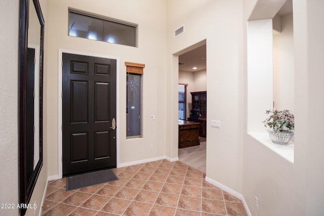 tiled entrance foyer with baseboards and visible vents