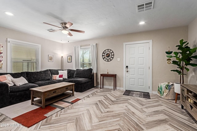 living room featuring baseboards, visible vents, ceiling fan, and recessed lighting